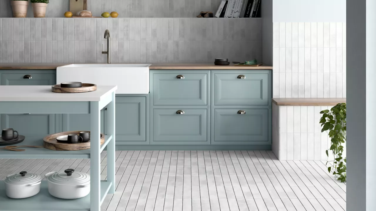 This bright and cheery kitchen features white handmade-look subway tile floor and wall tile and blue cabinets.