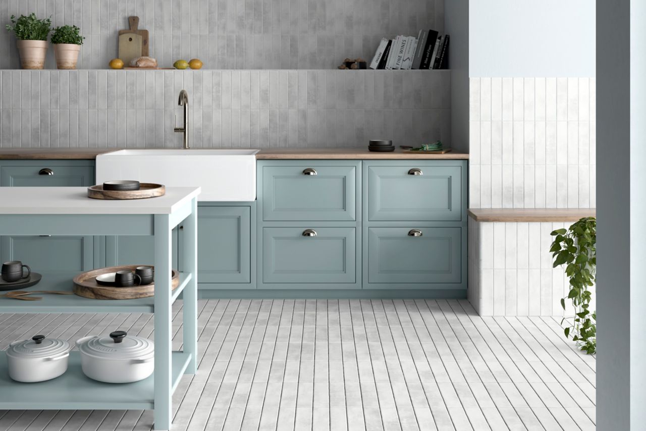 This bright and cheery kitchen features white handmade-look subway tile floor and wall tile and blue cabinets. 