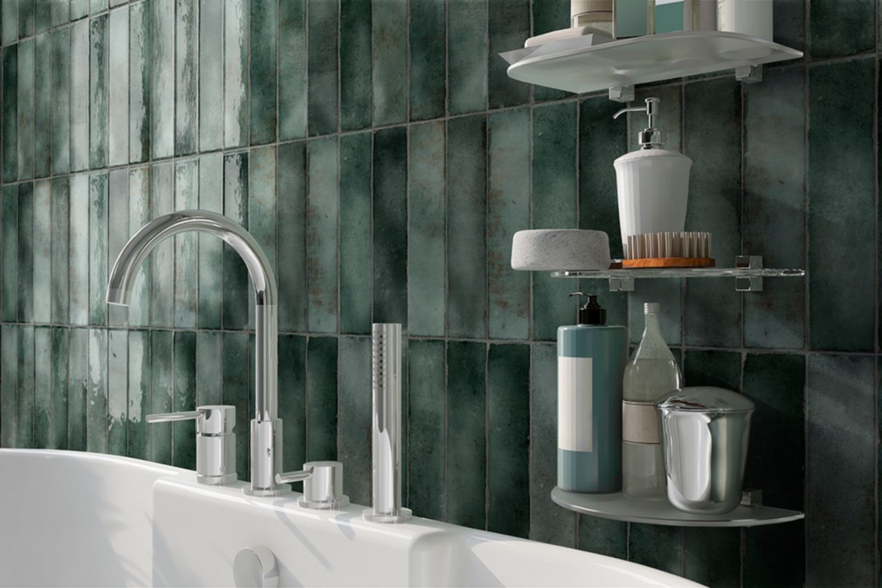 This bathroom backsplash features jade-colored subway tiles in varied green tones that have been installed vertically to create a distinctive look.