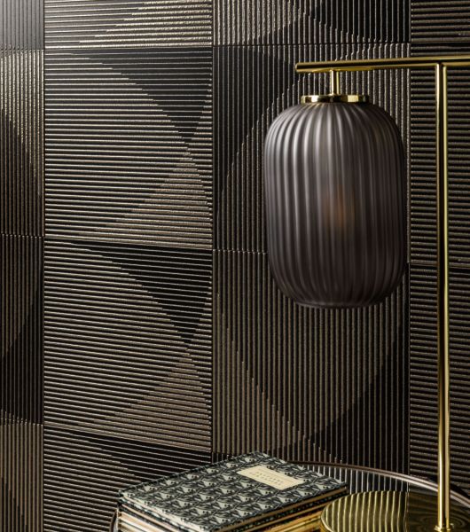 This area features a wall covered in dark, geometric metallic tile with raised gold lines that have been multi-fired to create additional dimension.