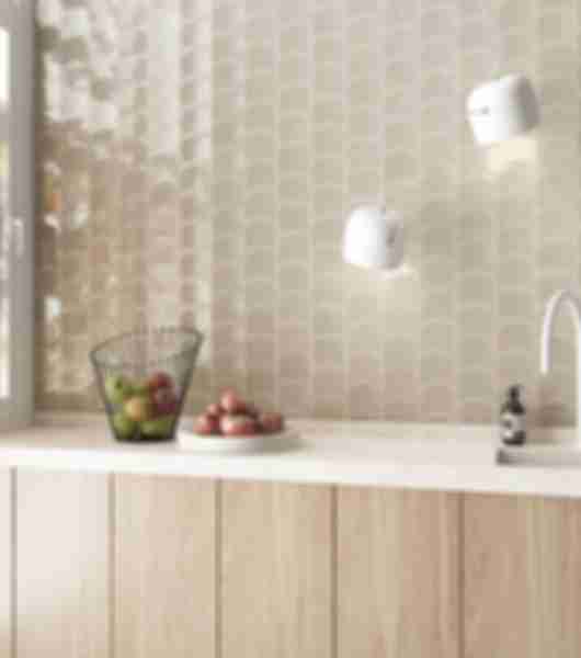 A bright, modern kitchen with a beige wave-shaped tile backsplash.