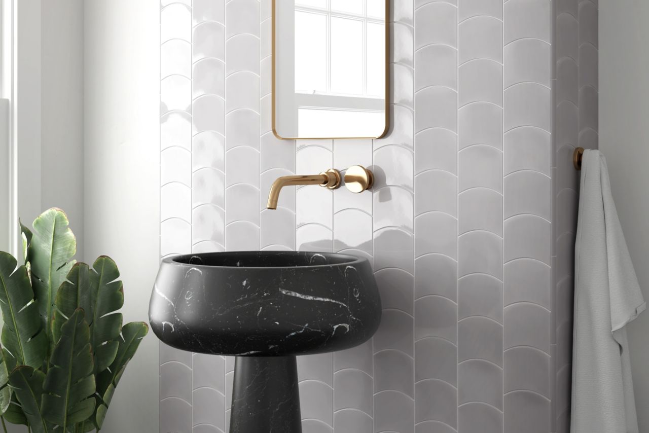A modern bathroom with a white wave-shaped tile backsplash and a black pedestal sink.