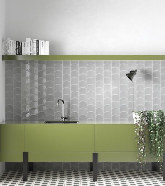 This kitchen features grey wave-shaped tile backsplash and green cabinets.