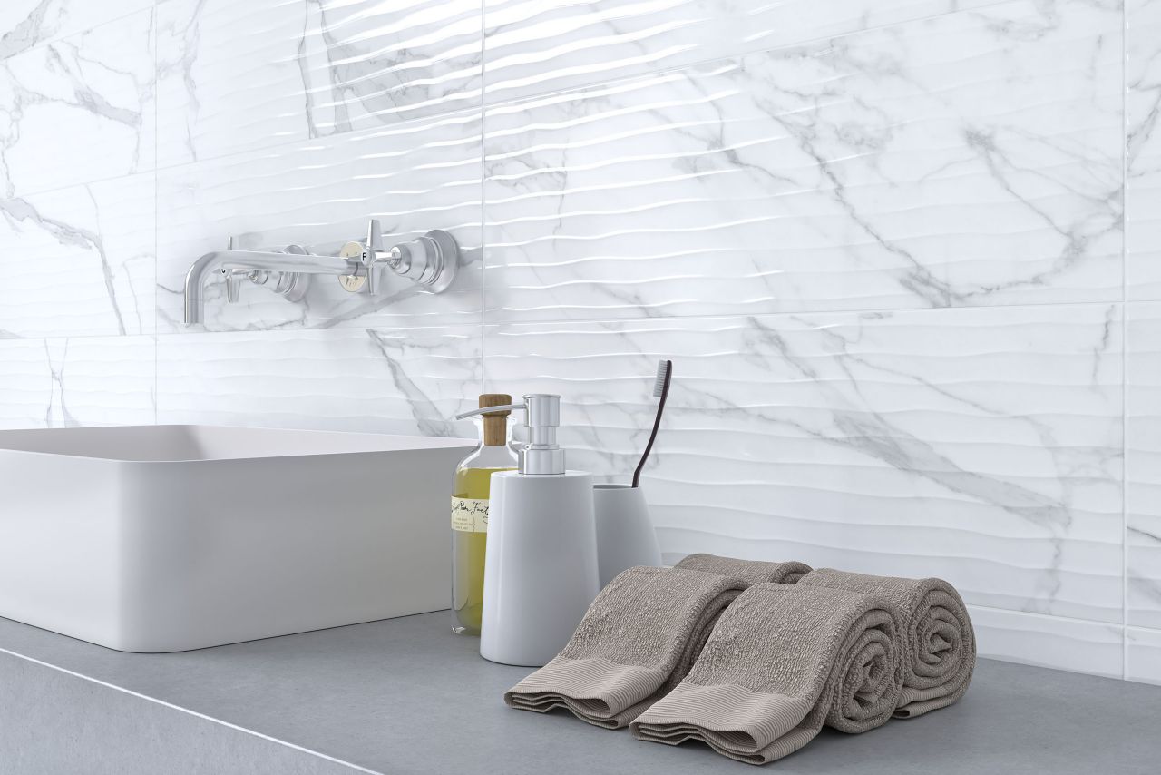 This bright white bathroom features a fluted marble-look tile backsplash.