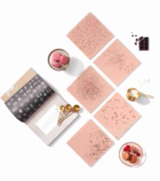 Flat-lay arrangement of square pink tiles with gold accents.