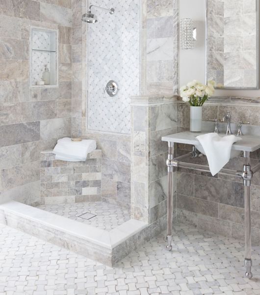 Stone-tiled bathroom with shower and sink.