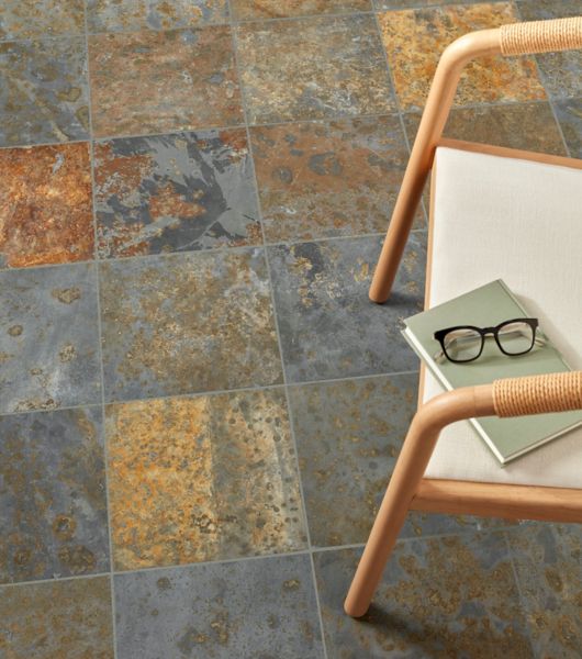 The floor of this room is covered in multi-colored square slate tiles. Each tile features a unique mix of brown, gray, tan and deep golden tones.