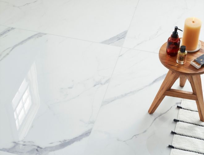 A bathroom features large-format marble-look porcelain tile all over the floors. The 48-inch square tiles mimic the appearance of white marble with light- and medium-gray veining.