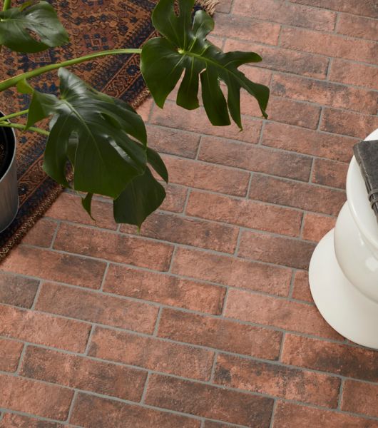 This living space features red brick-look floor tile installed in a classic offset pattern.