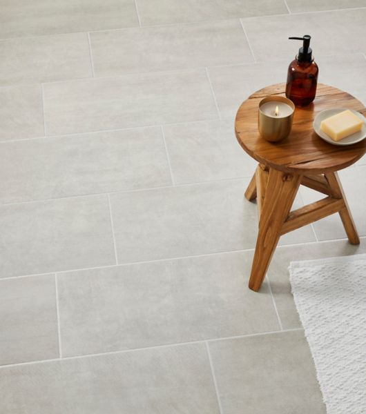 Large silver rectangular ceramic tiles with small wooden table.