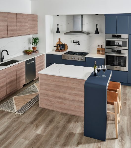 Blue and white kitchen with wood-look vinyl flooring.