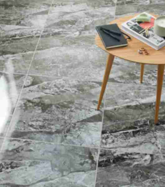 A ceramic marble-look tile floor with bold grey and white veining.