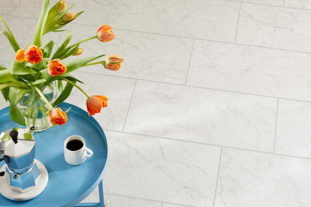 This bright kitchen floor features white marble-look tile.