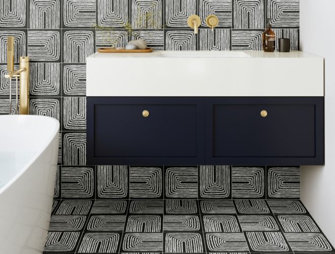 This chic modern bathroom features a black-and-white abstract-patterned tile on the floor and backsplash.