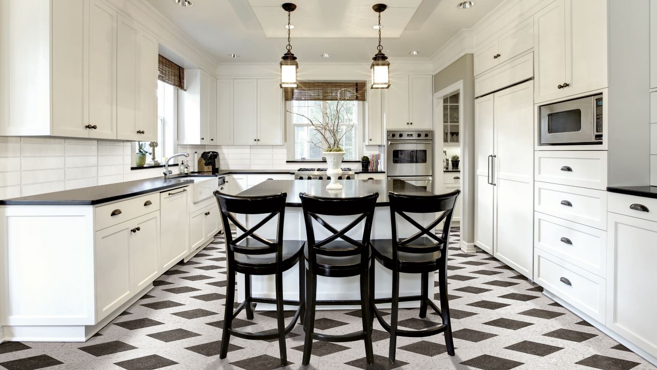 This bright open kitchen features a lapis with black tiled floor.