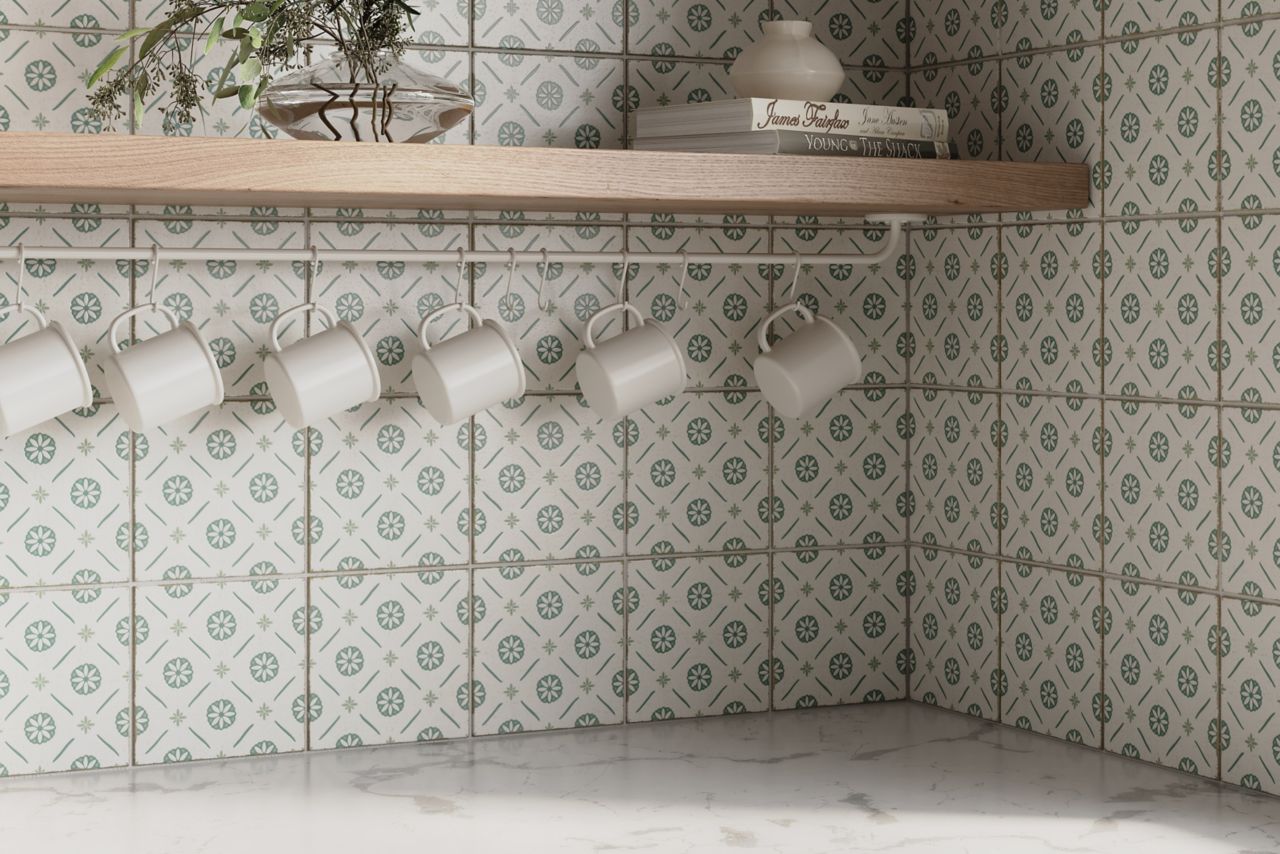 Kitchen backsplash featuring a green and white floral patterned square porcelain tile with wooden shelves and various cups and bowls.