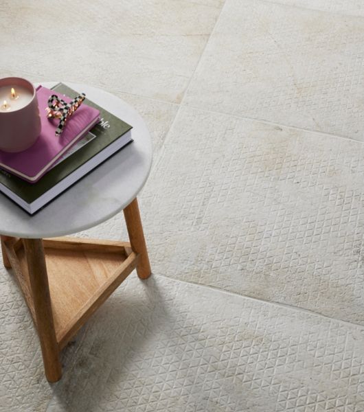 Living space with a floor covered in large-format, ivory-colored ceramic tile featuring a geometric recessed pattern.