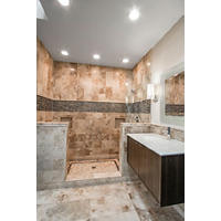 Thumbnail image of Bathroom area with walkin shower and large steamlined vanity.  Area is tiled in a heavily swirled travertine in a range of creamy and chocolaty hues with crystalline deposits throughout and a large mosaic border of marble and glass in deep brown rich tones that ties in the mosaic rug on feature on tile shower pan as well.