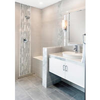 Thumbnail image of Bathroom tiled in various materials and sizes to make a modern looking grey and white bathroom with floating vanity and chrome fixtures.