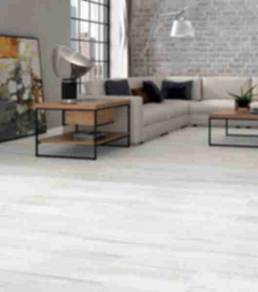 This floor is covered in large plank-shaped porcelain tiles that have a realistic appearance of light-tone wood.