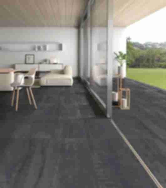 Patio area indoor/outdoor with porcelain flooring in dark charcoal and metallic color palette and a matte finish adding an industrial vibe to the modern decor and seating.
