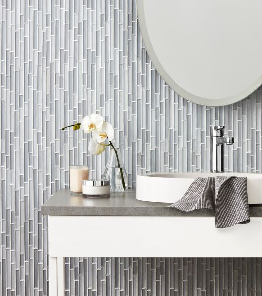 Bathroom vanity with grey and blue glass stria mosaic on wall.