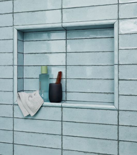 Blue tile niche with soaps and washcloth.