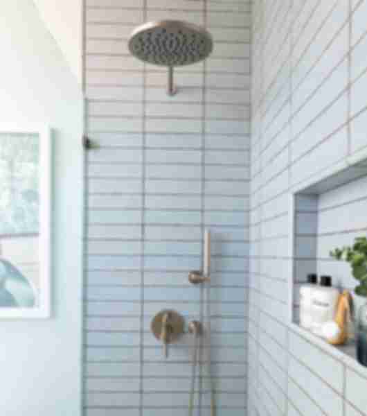 Shower with blue handmade-look subway tile.