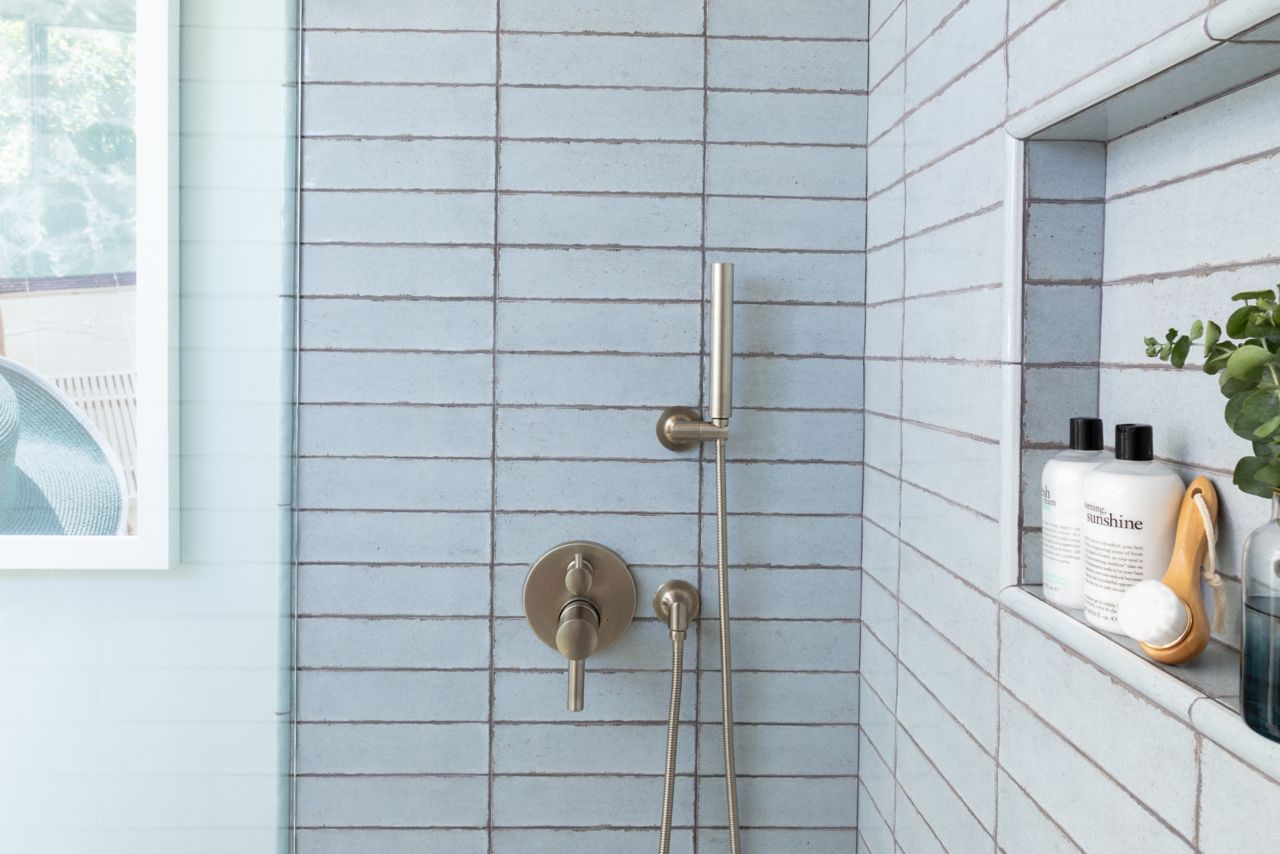 Shower with blue handmade-look subway tile.