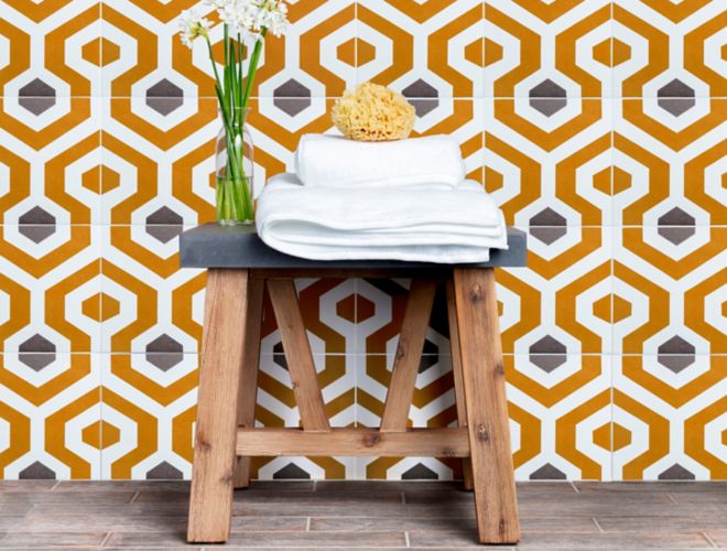 Shower wall with orange and grey geometric patterned tile.