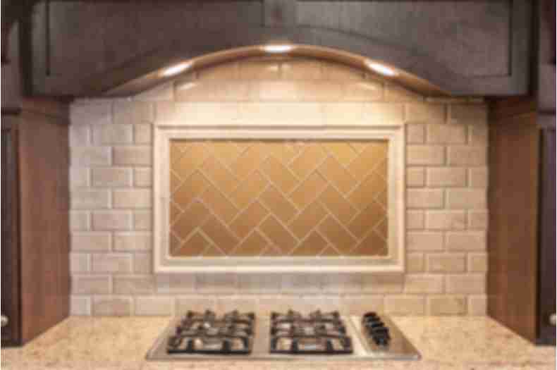 Beige subway tile on kitchen backsplash above stove.