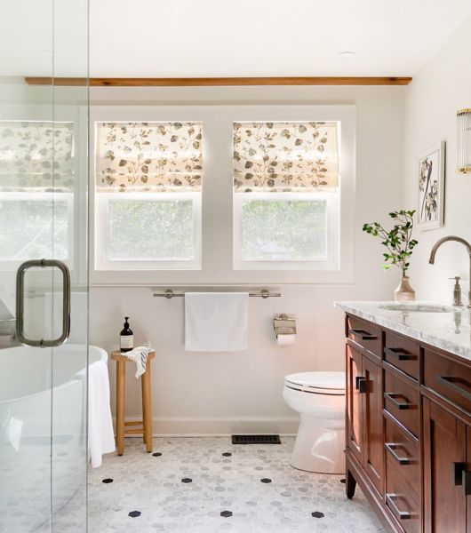 Bathroom with dark-wood sink vanity, mirror, plant and lots of natural light.