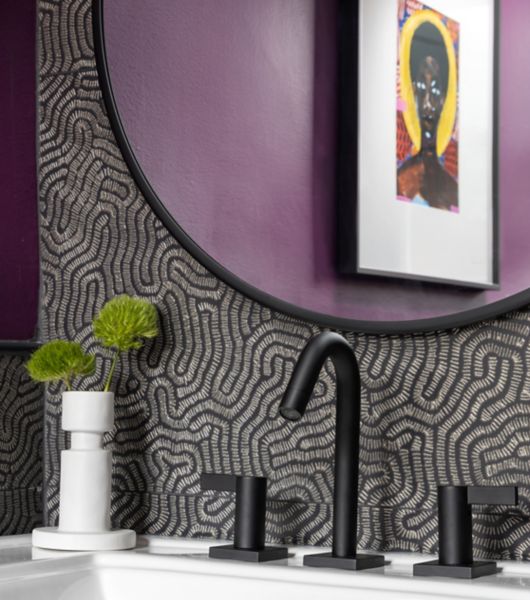 This modern bathroom features a black tile with abstract gold shapes.