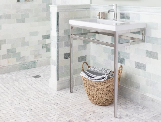 Bathroom with green marble on wall with white basketweave marble tile on floor.