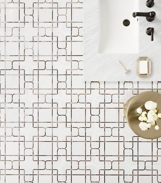 A bathroom floor tiled with a modern take on a plaid design using a mix of marble and metallic porcelain in a mosaic sheet. 