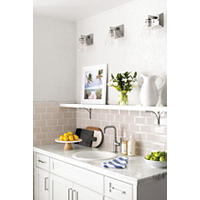 Thumbnail image of Small kitchen area with tiled walls and countertop.  Natural stone and resin profiles divide wall tile with beveled subway on lower half and raised patterned square white tile on upper half.  Counter is natural stone polished marble and edges of counter are same.
