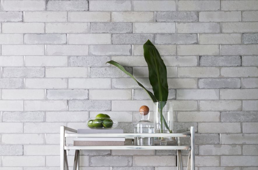 Industrial bar area with grey brick wall and silver accents.