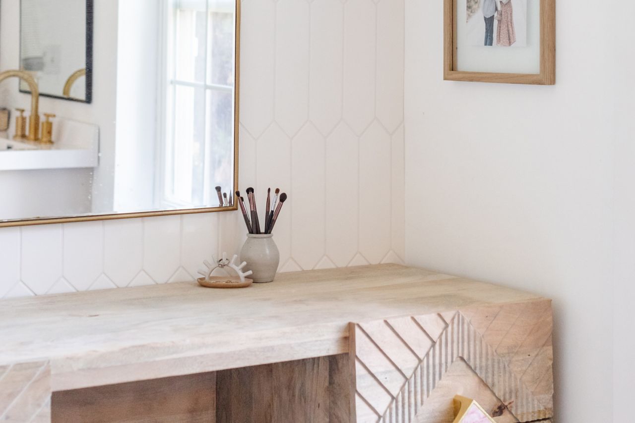 This boho-inspired bathroom features a white picket-shaped tile wall.