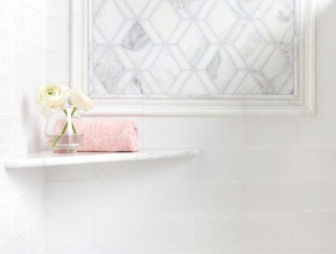 Feminine shower with white marble mosaic and white subway tile.