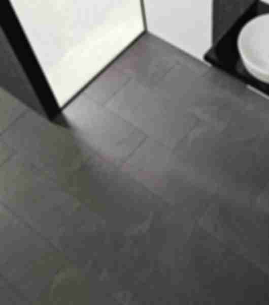Contemporary bathroom with black textured tile on floor.