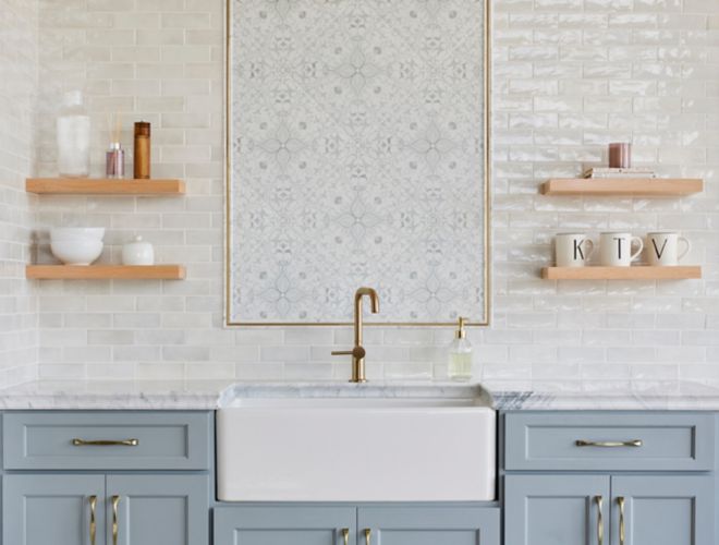This kitchen backsplash features a white handmade-look subway tile and an ornate patterned tile in a picture frame.