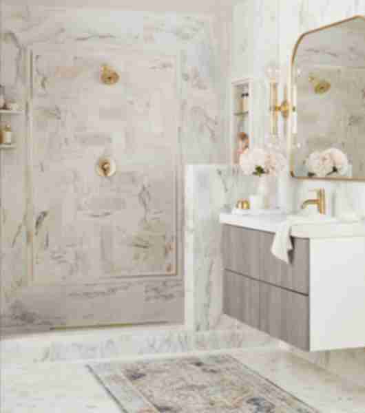 White marble bathroom with shower and sink.