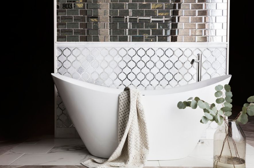 White arabesque and mirror subway tile in bathroom with elegant freestanding tub.