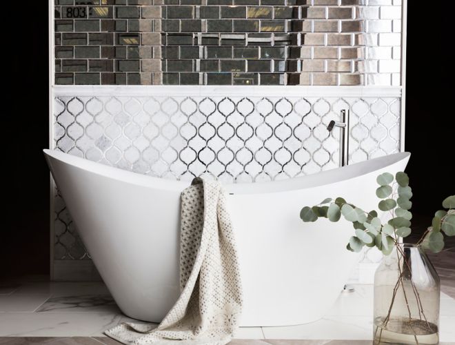 White arabesque and mirror subway tile in bathroom with elegant freestanding tub.