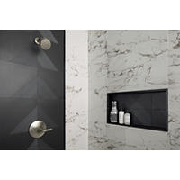 Thumbnail image of Close up of walk in shower wall framed deco in black and metallic with lines to make patterns niche is featuring the same tile and both are framed in black profiles.  Marble look large rectangular tiles with white background and black/grey veining is the field tile on walls.