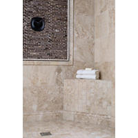 Thumbnail image of Using natural marble in warm creamy beiges hands in Browns with a white background this shower area it has an array of shapes sizes in depth with use of ace trea in a darker marble and glass tile to accent the fixture area framed out and matching wall tile profiles and accented with a dark metal stainless trim piece the tile on the front of the bench is a small subway tile ran vertically to give a little touch of modern style whereas the rest of the area feels very traditional with trim pieces in skirting all flowing in the same colors but with the beautiful pattern of natural stone.