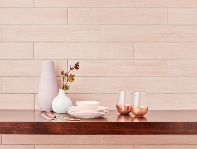 Blush pink wood-look wall tile in kitchen with feminine dishware.