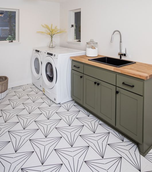 This is a laundry room featuring a floor covered in white hexagon tile with black lines that create a repeating geometric pattern.