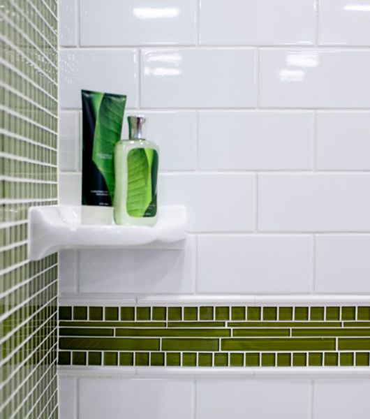 White subway wall tile and green glass mosaic tile on shower wall.