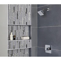 Thumbnail image of Photo of shower wall with recessed niches and waterfall deco in mixed glass and stone along wiith large profile rectangle tile in grey tones. 
